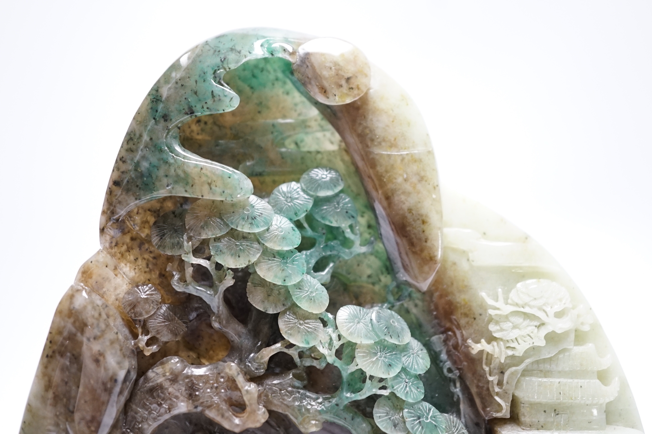 A Chinese jadeite boulder carving on hardwood stand, 17cm high